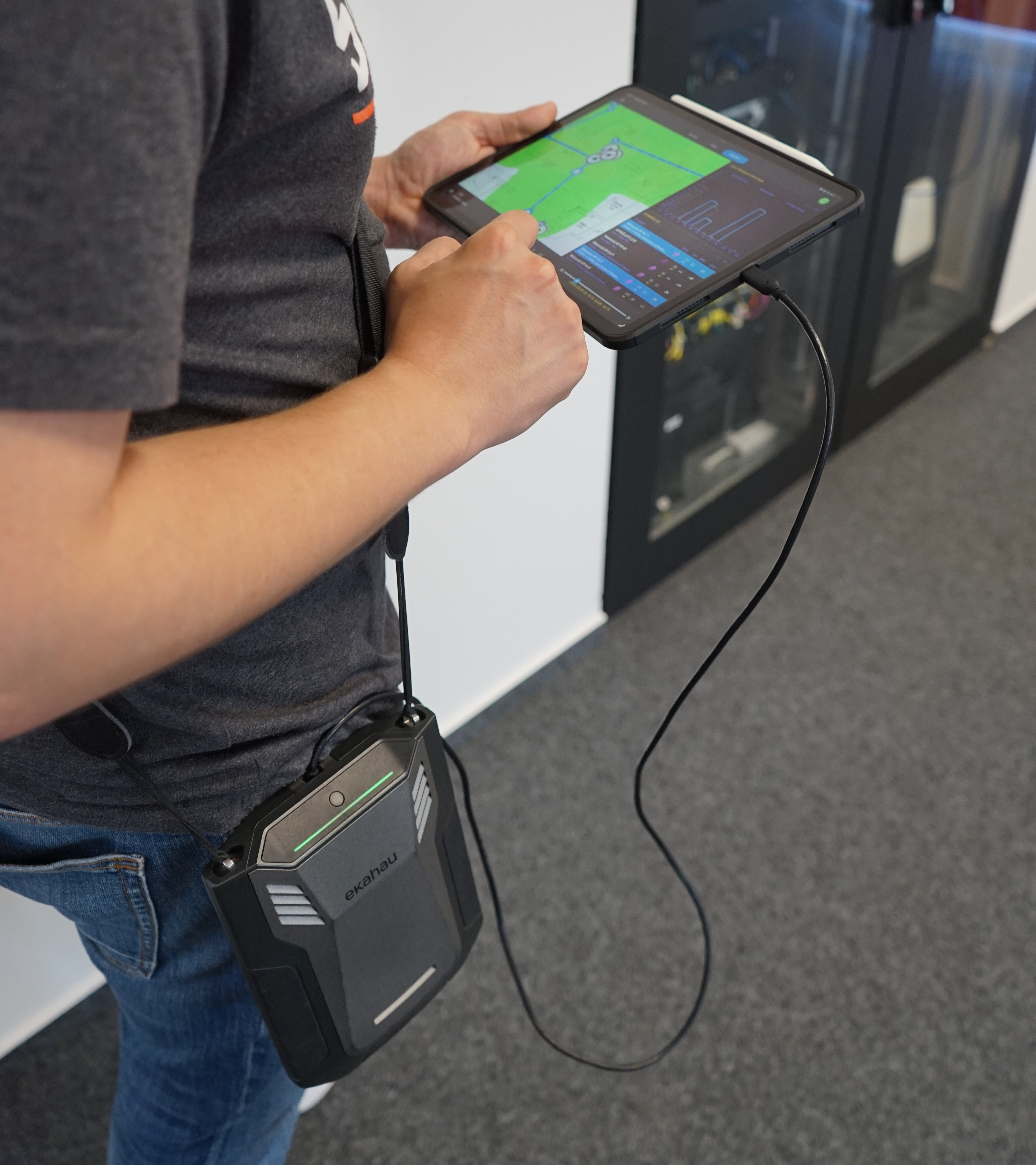 Person, die mithilfe eines Ekahau Sidekick und eines Tablets eine WLAN-Standortanalyse durchführt